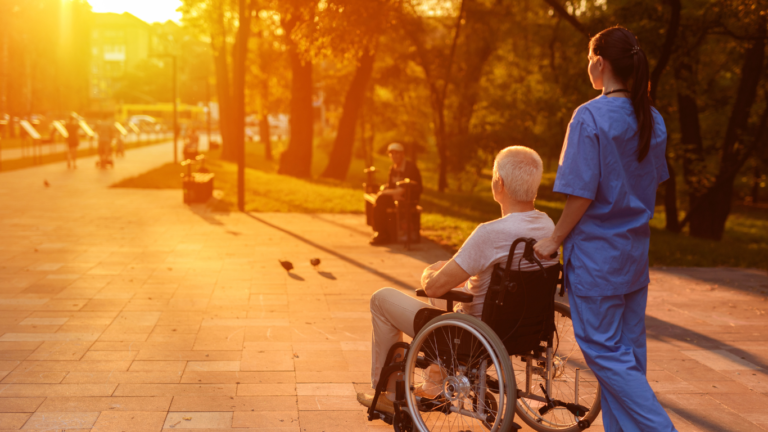 An image of a care worker strolling with a senior in a wheelchair